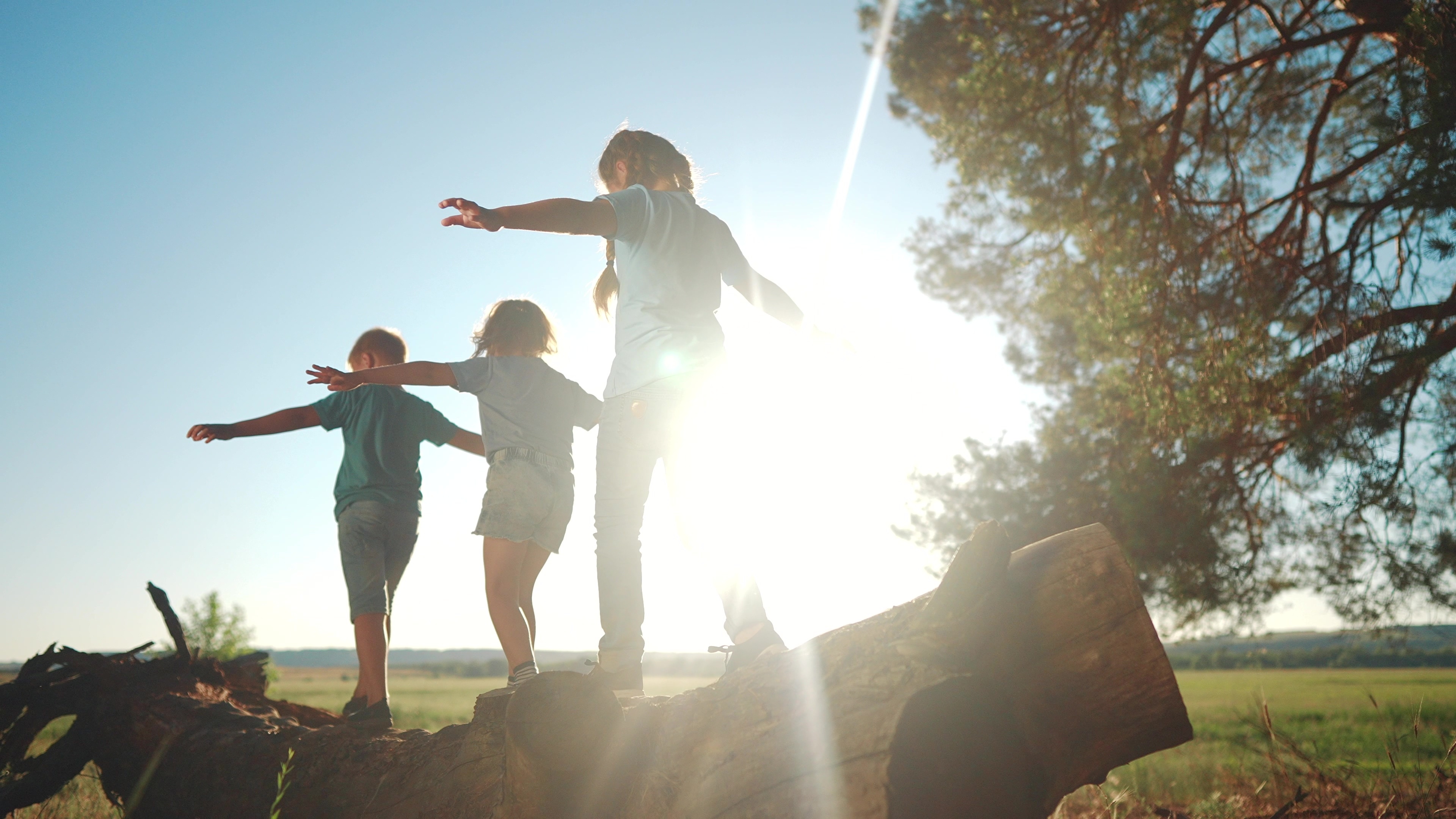 A child outside in dappled natural light, playing in a creekside setting